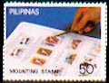Briefmarke mit Pinzette in Hand über Briefmarkenalbum